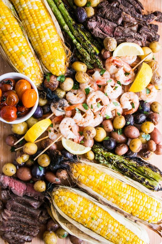 A surf-n-turf bbq board with lots of vegetables and all cooked on the grill!